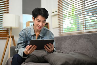 Young man using digital tablet while sitting at home