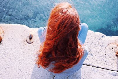 High angle view of woman sitting on pier