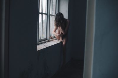 Woman looking through window