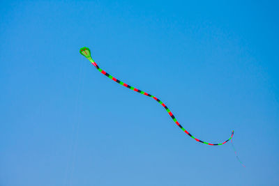 Low angle view of kite against clear blue sky