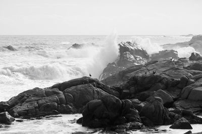 Scenic view of rocks in sea against sky