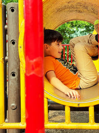 Side view of boy on slide at playground