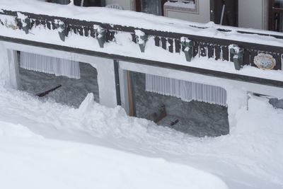 Snow covered house by building