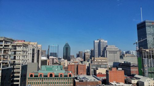 Cityscape against clear blue sky