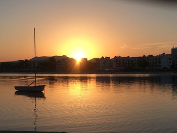 Boats in river at sunset