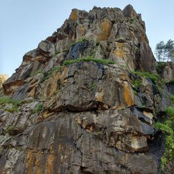 Low angle view of rocks on mountain against sky