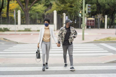 African wedding couple crossing the road hand in hand