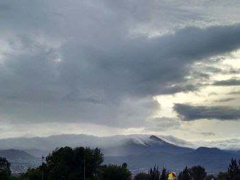 Scenic view of mountains against cloudy sky