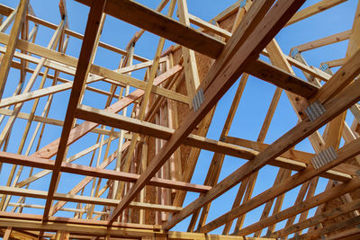 Low angle view of roof beams against sky