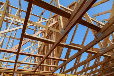 Low angle view of metallic structure against blue sky