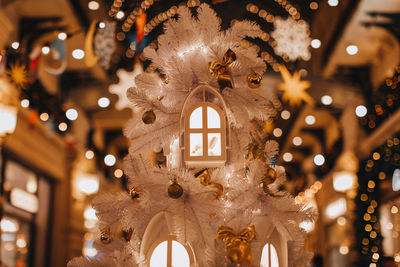 Magic christmas decorations white christmas tree with golden light and windows. cozy details