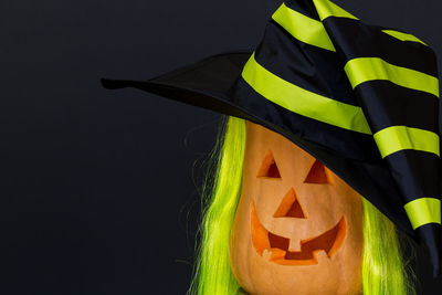 Close-up of witch hat on jack o lantern against black background