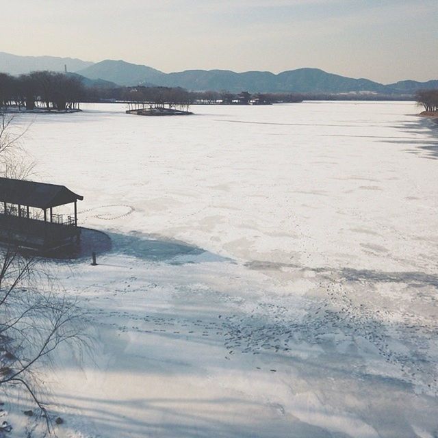 snow, mountain, winter, cold temperature, tranquil scene, tranquility, scenics, mountain range, beauty in nature, water, nature, season, beach, sky, weather, built structure, sand, landscape, idyllic, sea