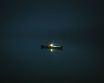 Low angle view of illuminated airplane against sky at night