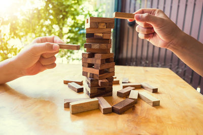 Cropped image of business colleagues playing block removal game on table