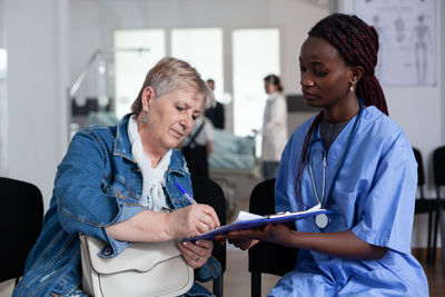 Side view of female doctor explaining to woman