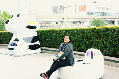 Portrait of smiling young woman sitting outdoors