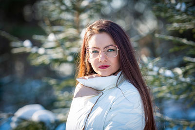 Portrait of a woman in white clothes in a cold winter forest