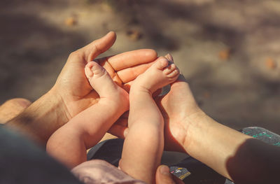 Midsection of couple holding legs of baby