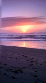 Scenic view of sea against dramatic sky during sunset