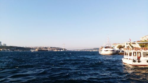 Sailboats in sea against clear sky