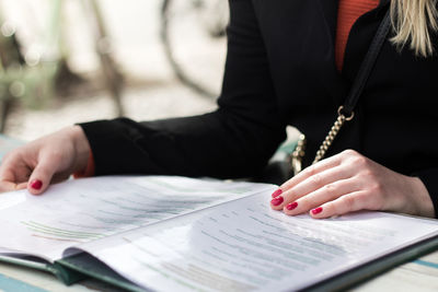 Midsection of woman reading book