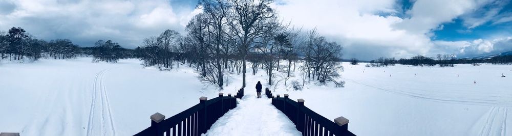 Panoramic view of snow covered land against sky