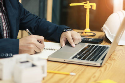 Midsection of man using laptop on table