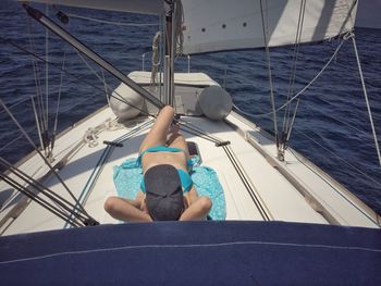 Low section of man on sailboat sailing on sea