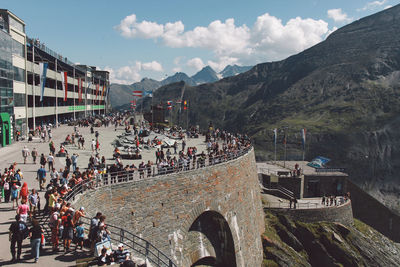 People in city with mountains against sky