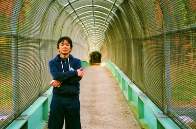 Full length of young woman walking on footbridge