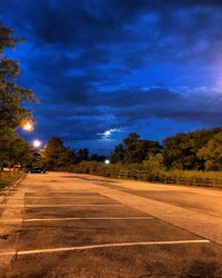 Road amidst trees against sky at night