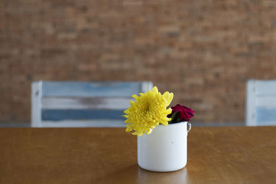 Close-up of flower vase on table against wall