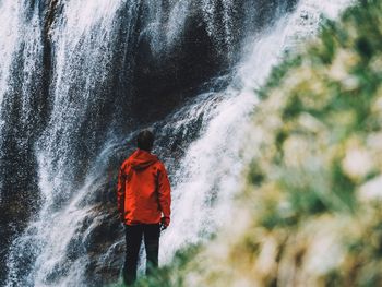 Person standing next to waterfall