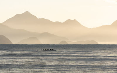 Scenic view of sea and mountains against sky during sunset