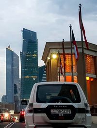 Cars on street against modern buildings in city