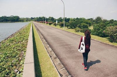 Rear view of woman walking on road