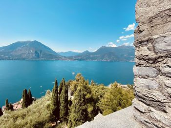 Scenic view of lake and mountains against blue sky