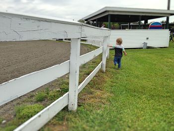 Boy playing on field against sky