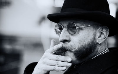 Close-up of man smoking cigarette against blurred background