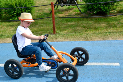 Boy driving quad bike, four wheel cycle car, spring brightly morning, sunny day