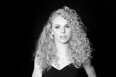 Portrait of woman against black background