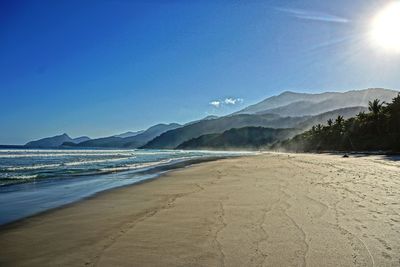 Scenic view of beach against clear blue sky