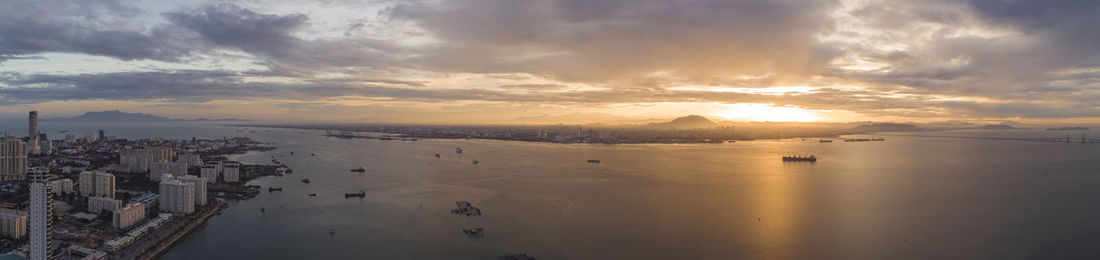 Panoramic view of buildings against cloudy sky