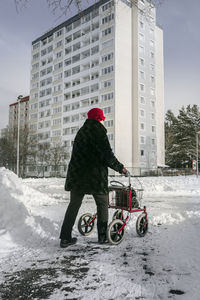 Senior woman with walking frame having walk at winter