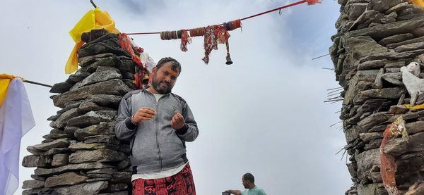 Low angle view of man standing on snow against sky