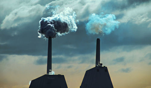 Smoke emitting from chimney against sky