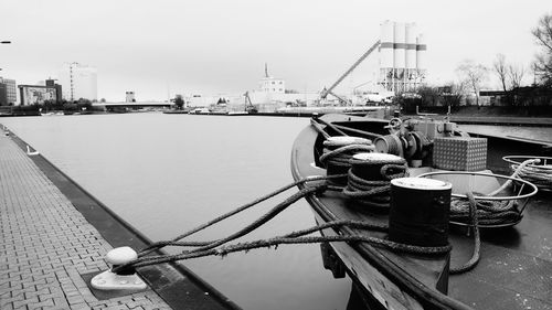 Boats moored at harbor against clear sky