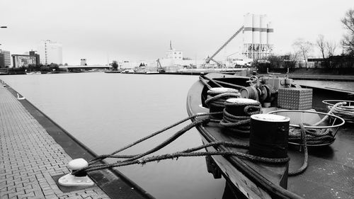 Boats moored at harbor against clear sky