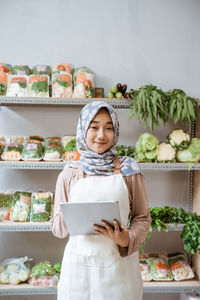 Portrait of smiling young woman standing in market